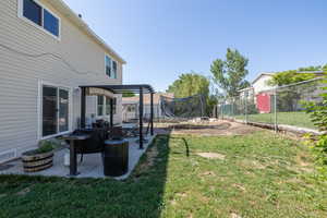 View of yard with a trampoline, a pergola, and a patio