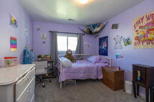 Bedroom featuring light colored carpet
