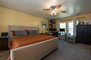 Bedroom with carpet flooring, a desk, and ceiling fan