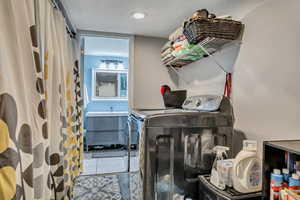 Laundry area with washer and clothes dryer and recessed lighting