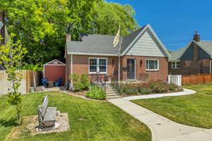 View of front of house featuring brick siding and a chimney