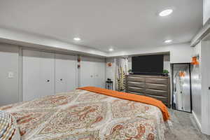Carpeted bedroom featuring multiple closets and recessed lighting