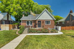 Bungalow-style home featuring brick siding and a chimney