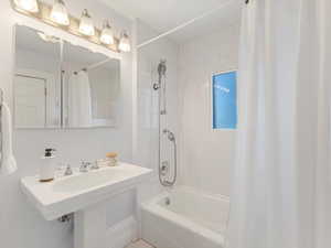 Bathroom with shower / bath combination with curtain