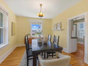 Dining space featuring light wood finished floors, a chandelier, and baseboards