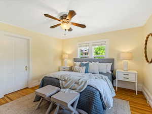 Bedroom with wood finished floors, baseboards, and a ceiling fan