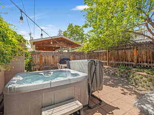 Fenced backyard with a hot tub and a patio