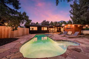 Pool at dusk featuring a patio
