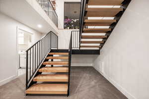 Staircase with carpet floors and baseboards