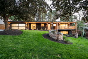 Back of property featuring a balcony, an attached garage, and brick siding