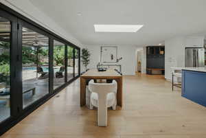 Recreation room with a skylight, light wood-type flooring, and recessed lighting