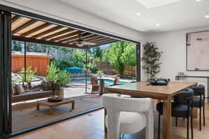 Dining space featuring hardwood / wood-style floors, recessed lighting, a ceiling fan, and a skylight