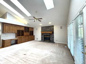 Great room with vaulted ceilings, sky lights, ceiling fan, gas fireplace and built-in cabinets.