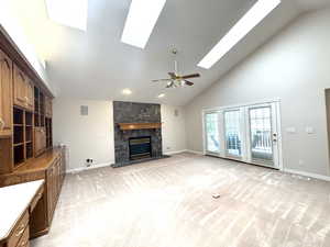 Great room with vaulted ceilings, sky lights, ceiling fan, gas fireplace and built-in cabinets.