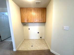 Washroom featuring electric dryer hookup, built-in cabinets.
