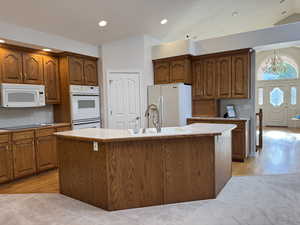KVaulted kitchen with dual ovens and built in glass cabinets and hardwood floor.