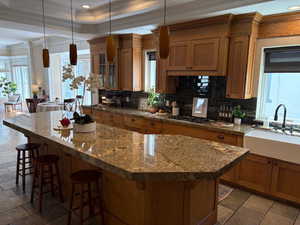 Kitchen looking back to semiformal eating area, farm sink, granite counters and travertine tile