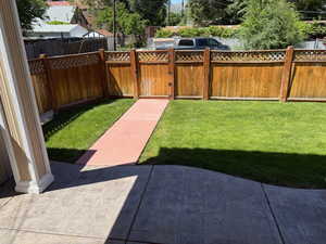 Fenced backyard with gate out to parking area