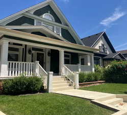 View of front of home with covered porch and a front lawn