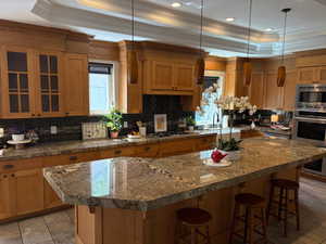 Kitchen featuring ornamental moldings, can lights, backsplash, and appliances with stainless steel finishes