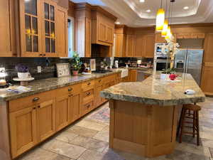 Kitchen with a large breakfast bar and cabinets that reach the ceiling