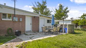 Rear view of property with brick siding and a patio