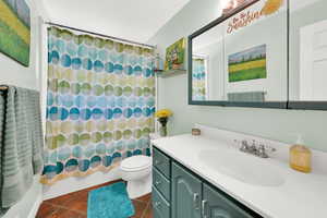 Full bathroom featuring vanity, toilet, and shower / bathtub combination with curtain