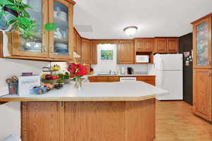 U Shaped Kitchen with white appliances, free standing range, range hood, and light colored laminate countertops