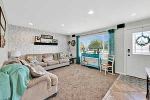 Living room with recessed lighting, healthy amount of natural light, wallpapered walls and tile entry