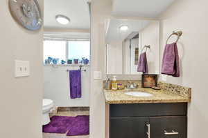 Bathroom with vanity, toilet, baseboards, and tile  floors