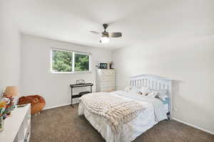 Bedroom featuring carpet floors, baseboards, and ceiling fan