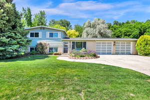 Split level home with brick siding, and a attached 2 car garage