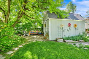 Storage shed with adjacent patio pavers and shaded seating/gathering area.