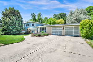 Cute home featuring a 2 car garage, concrete driveway, brick siding, and a front lawn