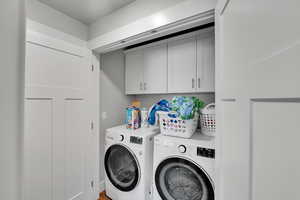Washroom with cabinet space and washer and dryer
