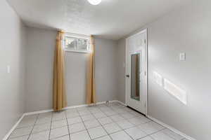 Spare room featuring a textured ceiling and baseboards