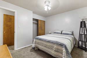 Carpeted bedroom featuring a closet, baseboards, and ceiling fan