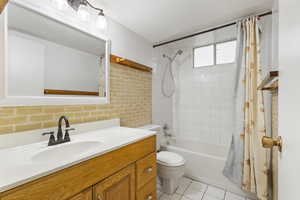 Full bath with vanity, toilet, shower / bathtub combination with curtain, and tile patterned floors