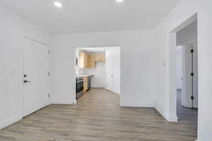 Kitchen featuring appliances with stainless steel finishes, light wood-type flooring, light countertops, baseboards, and recessed lighting