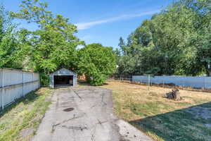 View of yard with a detached garage and an outbuilding