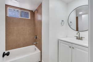 Bathroom featuring vanity, shower / tub combination, and a textured ceiling