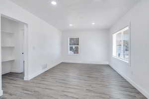 Unfurnished bedroom featuring recessed lighting, wood finished floors, a spacious closet, baseboards, and a closet