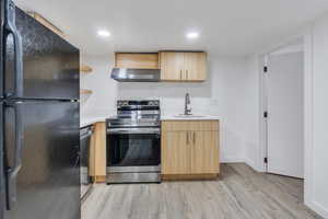 Kitchen featuring freestanding refrigerator, electric stove, ventilation hood, open shelves, and light brown cabinetry