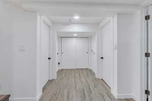 Hall with light wood-style floors and baseboards