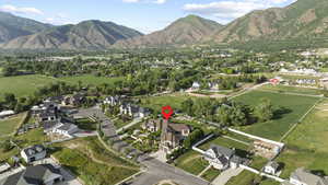 Aerial view of property and surrounding area with nearby suburban area and a mountainous background