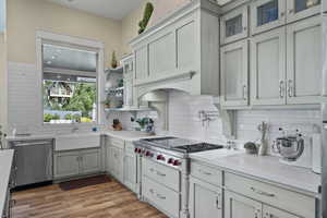 Kitchen with a sink, stainless steel appliances, backsplash, light countertops, and light wood-style floors