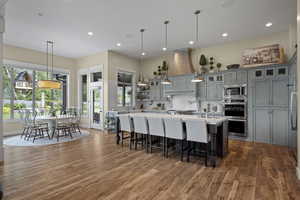 Kitchen with appliances with stainless steel finishes, light countertops, wood finished floors, tasteful backsplash, and recessed lighting