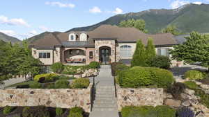 French country inspired facade featuring a mountain view, brick siding, and a standing seam roof