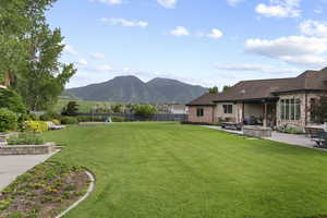 View of yard with a playground, a patio area, a mountain view, and a fire pit
