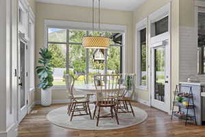 Dining space with healthy amount of natural light, wood finished floors, and baseboards